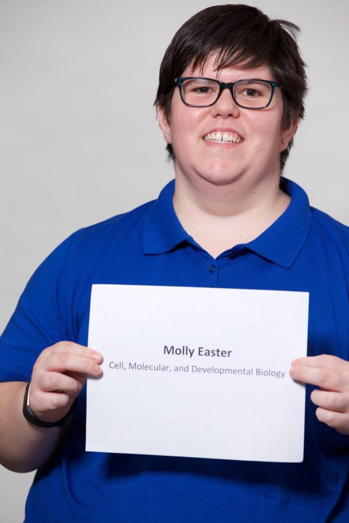 A person holding up a paper in front of their face.